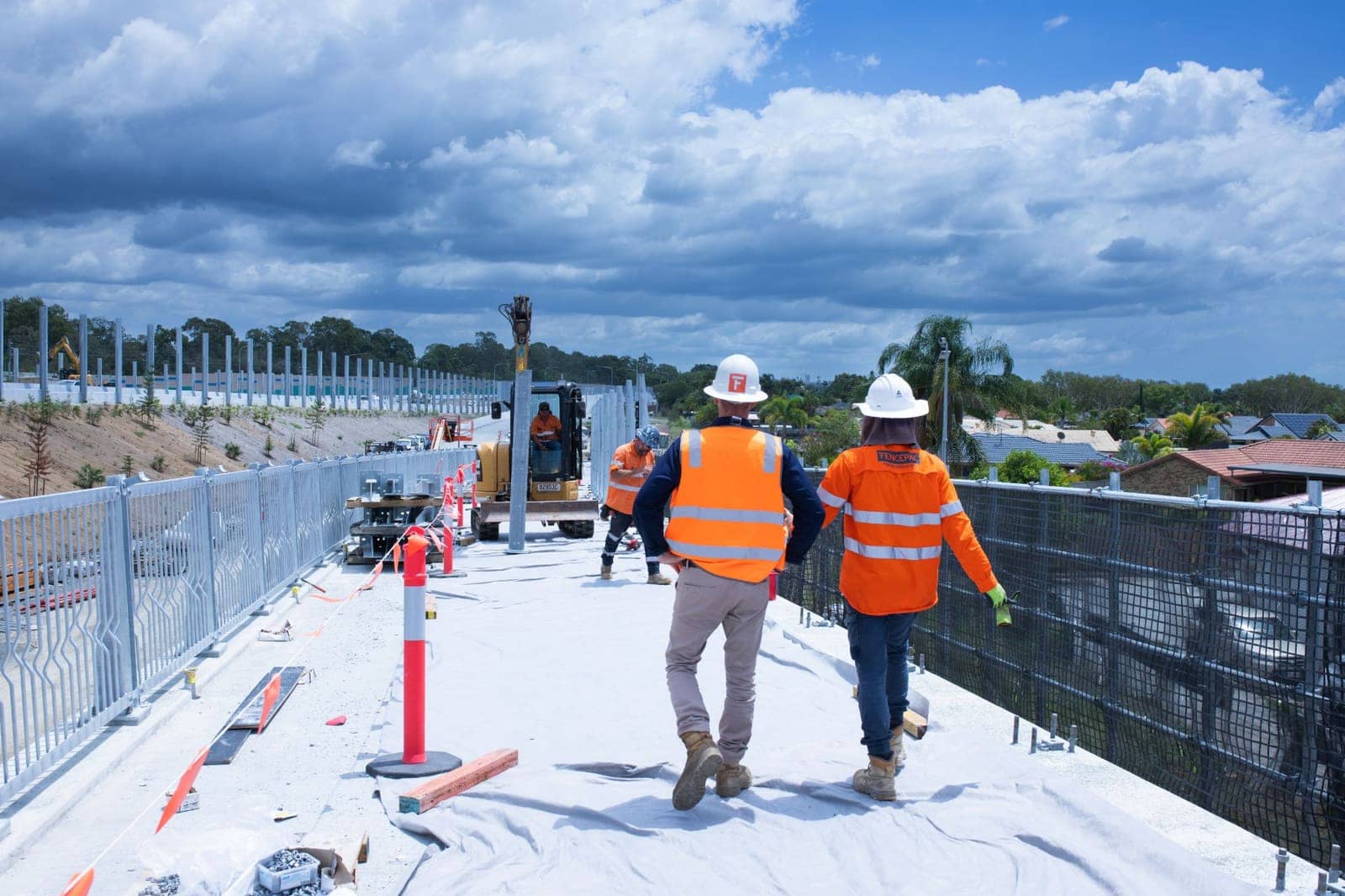Fencepac crew on a bridge deck while an excavator places a Noise Wall post