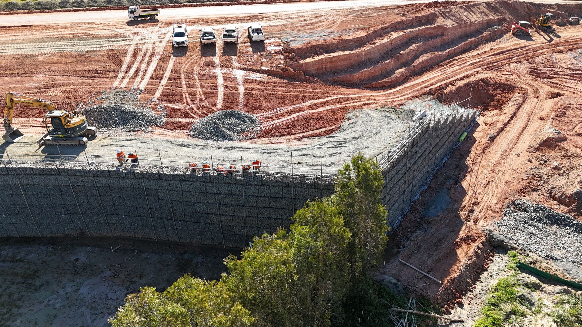 Massive gabion retaining wall aerial view with red earth and bushland