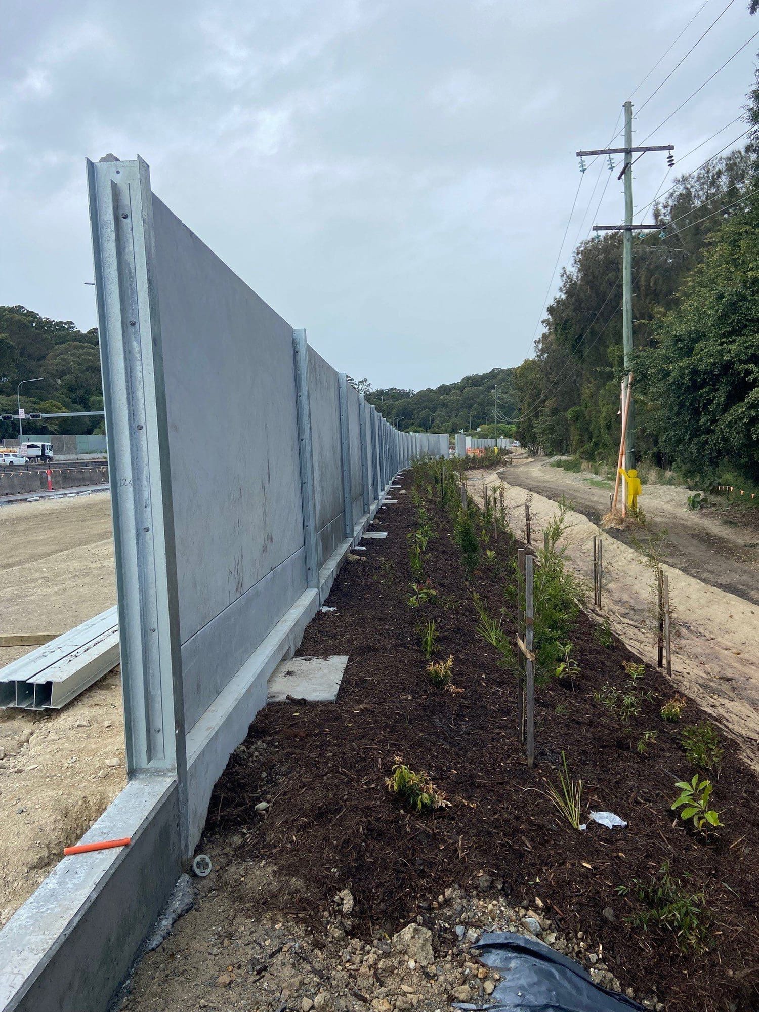 Concrete noise barrier panels with landscaping behind
